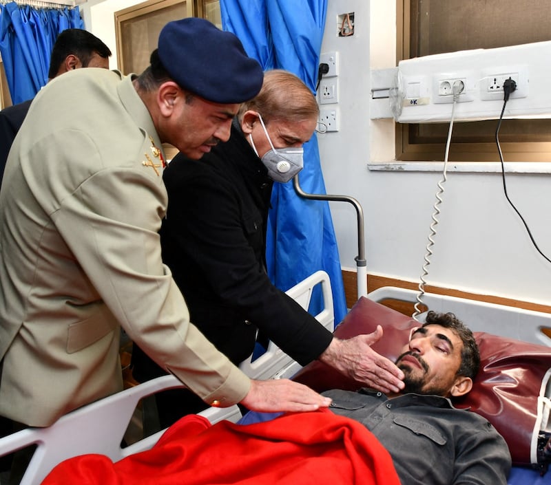 Pakistan's Chief of Army Staff, Asim Munir, and Prime Minister, Shehbaz Sharif, visit a man injured in the blast. Reuters
