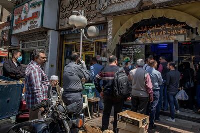 People wait in line to order fish to make fesikh, a traditional dish, which is eaten during the Sham el-Nessim holiday, in Cairo, Egypt, Tuesday, April 14, 2020. Sham el-Nessim signifies the arrival of Spring and people gather at public spaces and gardens to enjoy their time off and eat the fish dish, a unique Egyptian tradition practiced since the days of the Pharaohs. However, with the coronavirus outbreak most people will be celebrating in their homes this year. (AP Photo/Nariman El-Mofty)