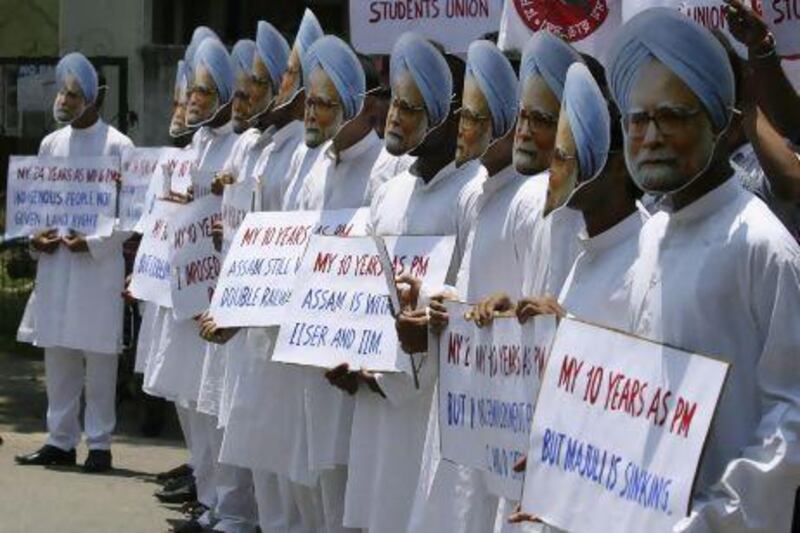 Demonstrators wearing masks of India's prime minister Manmohan Singh hold placards during a protest in Guwahati.