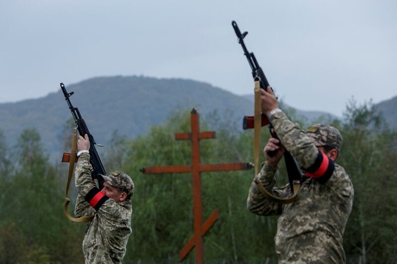 Ukrainian servicemen shoot in the air during a funeral ceremony for a soldier who was killed fighting Russian troops during the liberation of Kharkiv.  Reuters