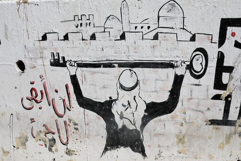 A graffiti depicting a Palestinian refugee holding his former house key in Palestine and reading in Arabic 'We will not remain refugees' is seen on a wall of the Baqa'a Refugee Camp about 20km north of Amman, Jordan. EPA