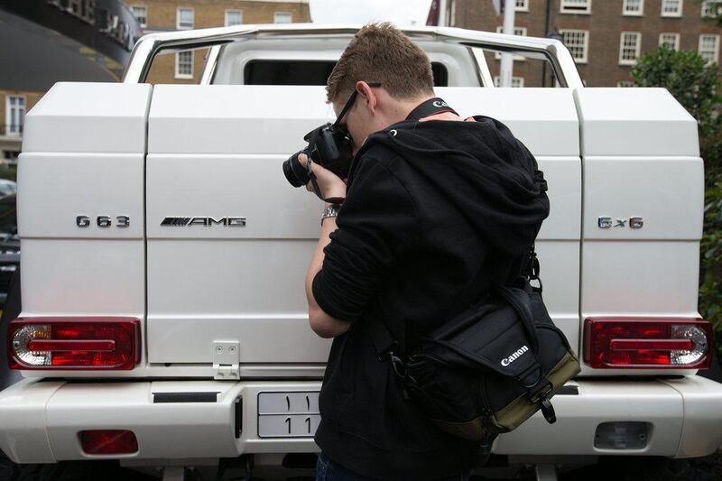 An admirer photographs the badge on the rear of a Saudi Arabian registered Mercedes G63 AMG 6x6. Carl Court / Getty Images