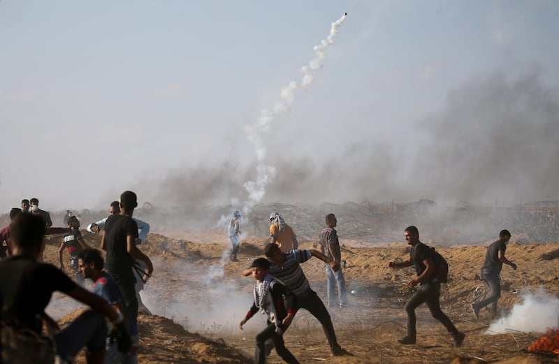 Palestinians react as tear gas was fired by Israeli troops during a protest at the Israel-Gaza border in the southern Gaza Strip on July 13. Reuters