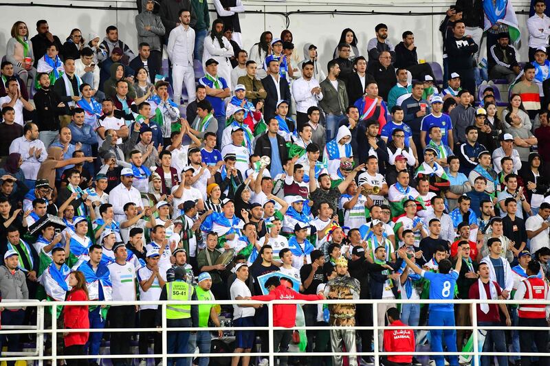 Uzbekistan supporters cheer. AFP