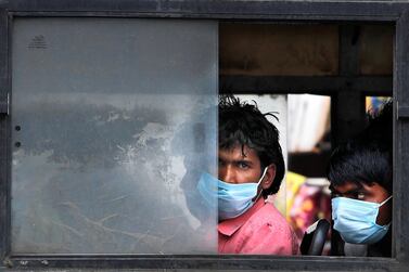 Migrant labourers wait on a bus to travel to their villages after New Delhi was placed under a week-long lockdown this week. AP