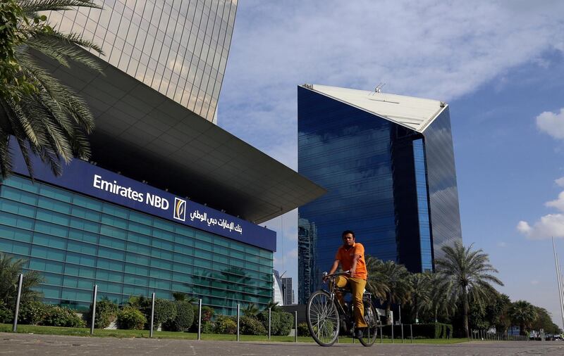 FILE PHOTO: A man rides a bicycle past Emirates NBD head office in Dubai, UAE January 30, 2018. REUTERS/Satish Kumar - RC1F060F2B60/File Photo