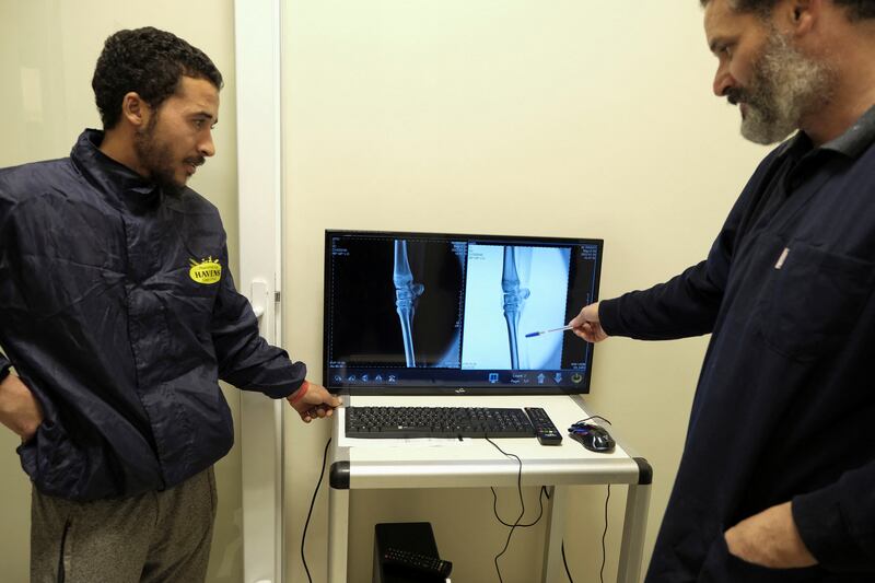 Walid Tandira explains the implications of an X-ray image to a horse owner.
