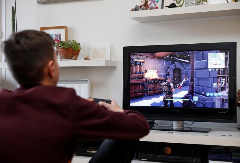 PARIS, FRANCE - DECEMBER 19: In this photo illustration a gamer plays the video game 'Fortnite Battle Royale' developed by Epic Games on a Sony PlayStation game console PS4 Pro on December 19, 2018 in Paris, France. The video game Fortnite Battle Royale was the star of the year 2018, more than 200 million players worldwide are registered online at this game phenomenon. (Photo Illustration by Chesnot/Getty Images)