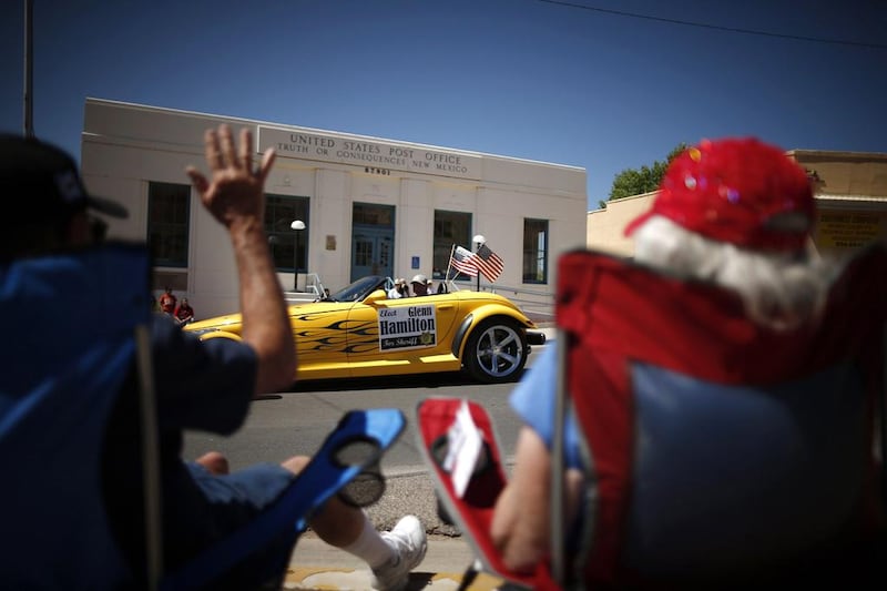 People wave at a car during the annual fiesta parade in Truth or Consequences, New Mexico. Lucy Nicholson / Reuters