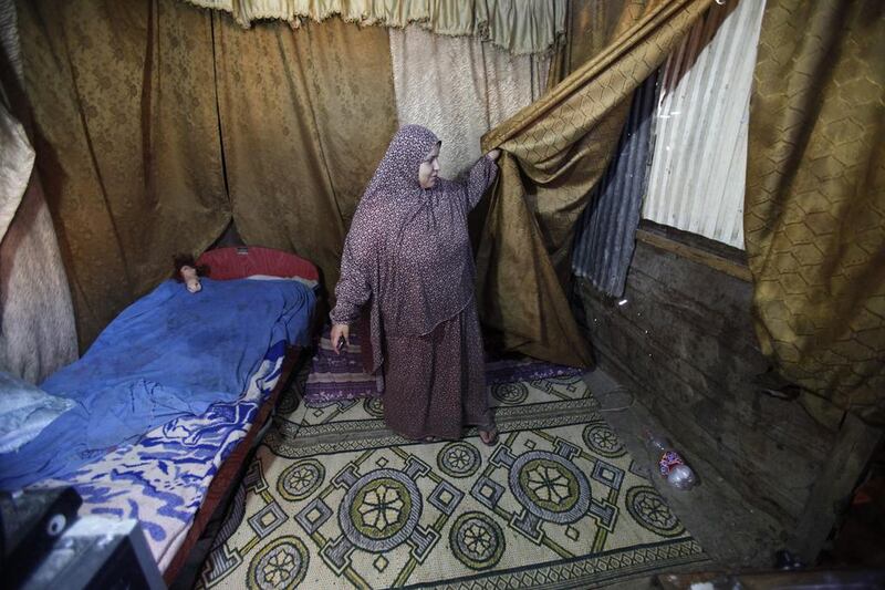 Ibtisam Alwadiya, 27, in her bedroom made from scrap wood and corrugated iron. Adel Hana / AP

