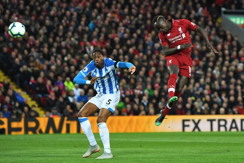 LIVERPOOL, ENGLAND - APRIL 26:  Sadio Mane of Liverpool scores his team's second goal as Terence Kongolo of Huddersfield Town challenges during the Premier League match between Liverpool FC and Huddersfield Town at Anfield on April 26, 2019 in Liverpool, United Kingdom. (Photo by Michael Regan/Getty Images)