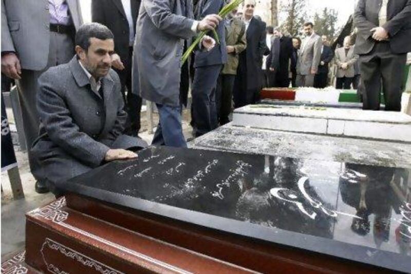 Iranian President Mahmoud Ahmadinejad prays at the grave of Gen Hasan Tehrani Moghaddam, a Revolutionary Guard commander, who was in charge of the country's missile programme and was killed in an explosion at an ammunition depot in November 2011, in a ceremony commemorating 33rd anniversary of Iran's 1979 Islamic Revolution on Saturday. Vahid Salemi / AP