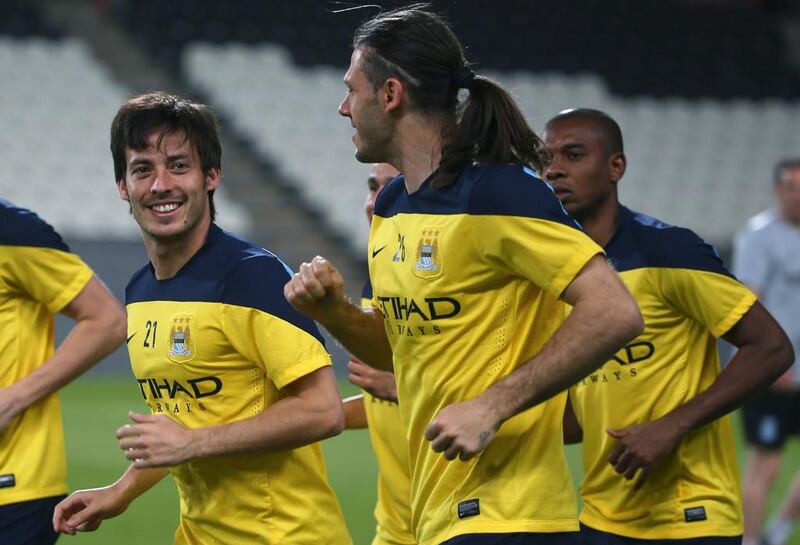 David Silva, left, and Martin Demichelis, right, during a run prior to the full training session on Wednesday held by Manchester City in Abu Dhabi. Marwan Naamani / AFP / May 14, 2014