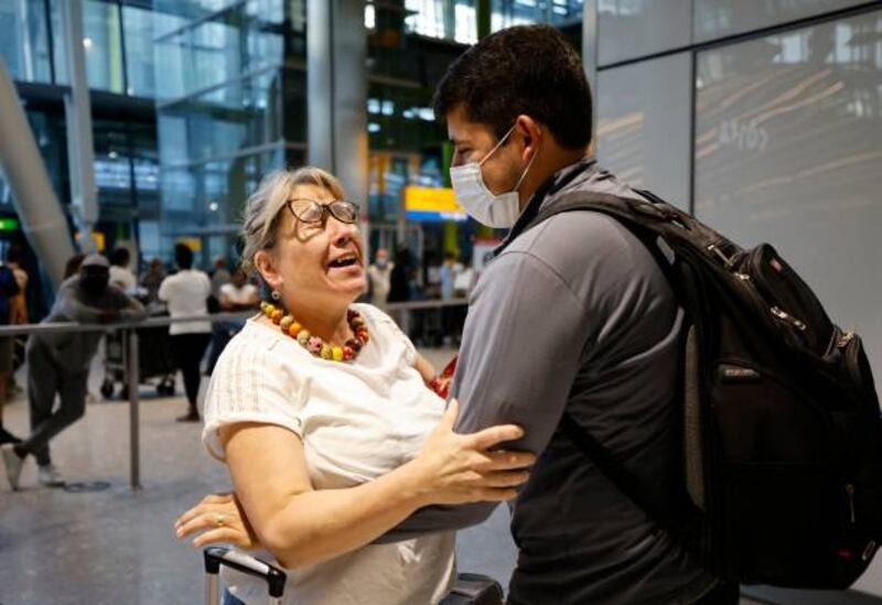 A mother embraces her son as he arrives from the US at Heathrow. People fully vaccinated in the US and EU, except France, can now travel to England without having to quarantine on arrival.