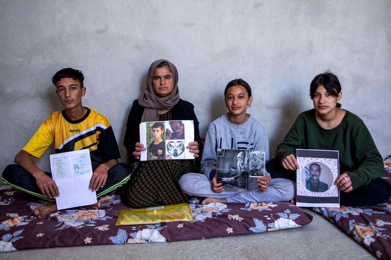 Bahar Elias, from Iraq's Yazidi community, and her son and daughters hold pictures of family members kidnapped by ISIS. AFP