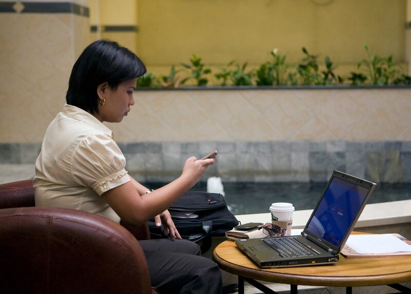 Dubai, UAE - July 21, 2009 - Stock image, woman using mobile phone and laptop at a cafe. (Nicole Hill / The National) *** Local Caption ***  NH Stock07.jpg