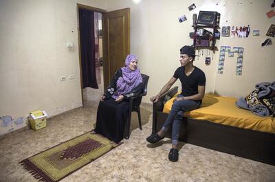 Aziza Safi, 58, during her evening prayer time in the bedroom of her youngest son Majd in Al Bureij in Gaza .Two of her sons are already out of Gaza and every morning she waits to know when the permits are ready for Ahmed and Majd who are planning to leave. (Photo by Heidi Levine For The National).