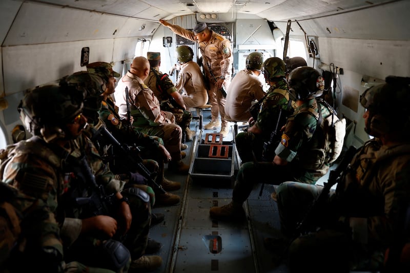 Iraqi Special Forces troops sit inside a helicopter during the "Solid Will" military operation against ISIS militants in the desert of Anbar, Iraq.