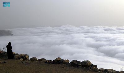 Hikers look on as clouds roll through the mountains of the Asir region. SPA