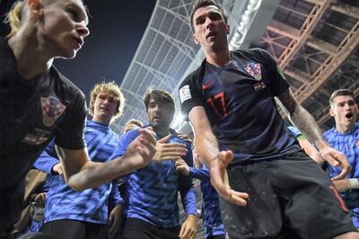 Croatia's forward Mario Mandzukic (C) offers to help AFP photographer Yuri Cortez after he fell on him with teammates while celebrating their second goal during the Russia 2018 World Cup semi-final football match between Croatia and England at the Luzhniki Stadium in Moscow on July 11, 2018. / AFP PHOTO / Yuri CORTEZ / RESTRICTED TO EDITORIAL USE - NO MOBILE PUSH ALERTS/DOWNLOADS
