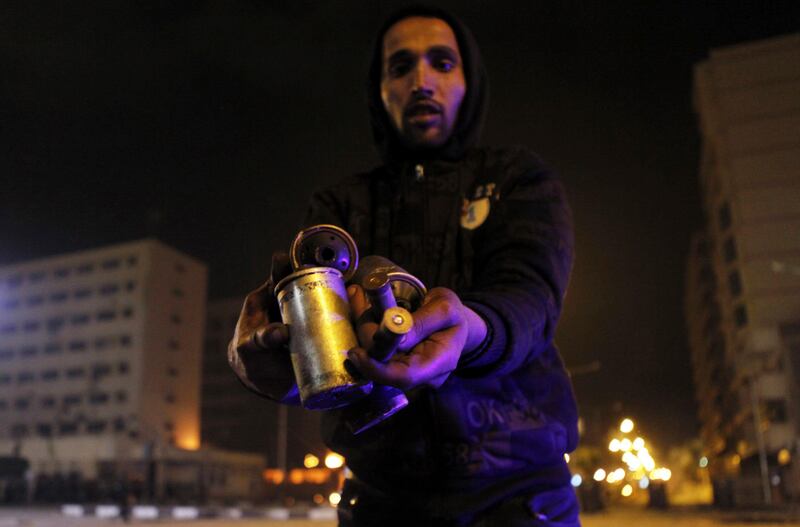 A protester, who opposes Egyptian President Mohamed Mursi, shows empty teargas canisters and rubber bullets during clashes with riot police in front of Security Directorate of Port Said after protesters started to set fire to it in Port Said city, 170 km (106 miles) northeast of Cairo March 4, 2013. Protesters hurled petrol bombs and stones at police officers who responded by firing teargas in Egypt's Port Said on Monday, a day after deadly demonstrations in the Suez Canal city. REUTERS/Amr Abdallah Dalsh (EGYPT - Tags: POLITICS CIVIL UNREST)