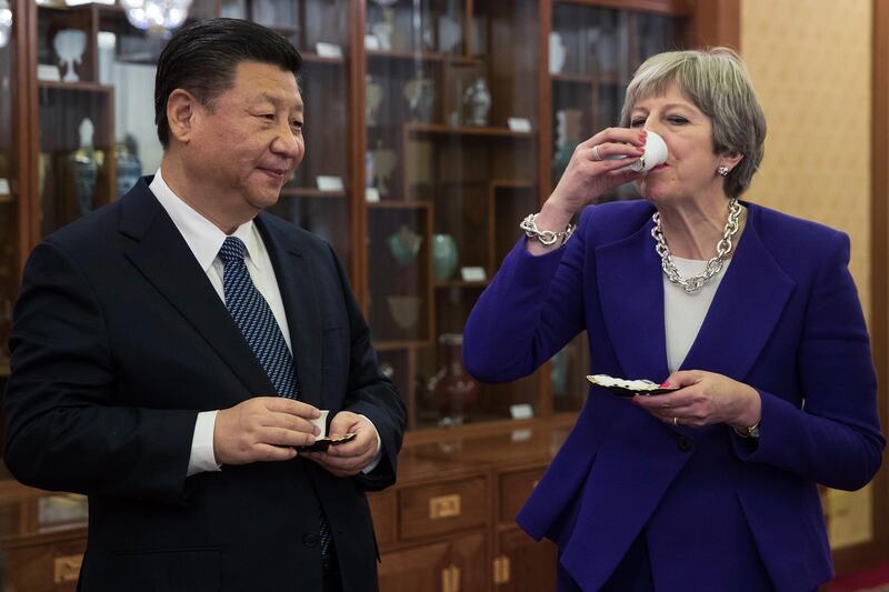 Theresa May, U.K. prime minister, right drinks from a cup as she stands next to Xi Jinping, China's president, during a tea ceremony at the Diaoyutai State Guest House in Beijing, China, on Thursday, Feb. 1, 2018. May is leading the largest business delegation her government has ever taken overseas as she seeks to put her Brexit troubles aside and make progress on boosting U.K. trade. Photographer: Dan Kitwood/Pool via Bloomberg