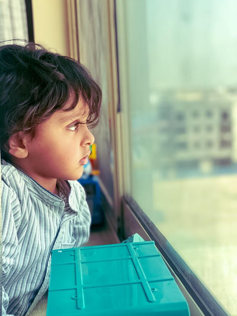 A child gazes out at the world from an apartment in the UAE. Courtesy of @farahkhan