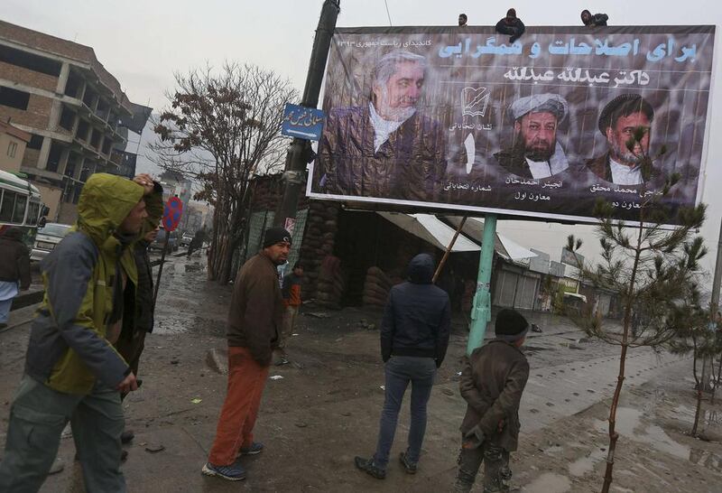 Men install a campaign banner of Afghan presidential candidate Abdullah Abdullah (L) during the first day of the presidential election campaign in Kabul on February 2, 2014. Omar Sobhani/Reuters  