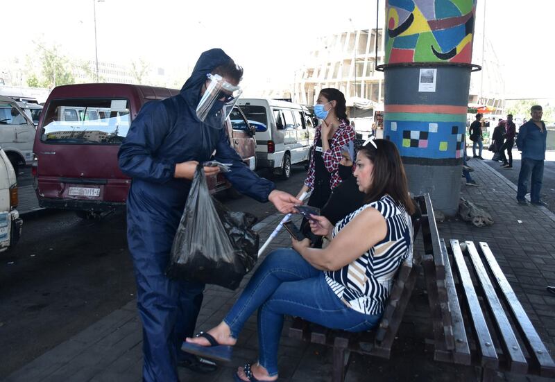 Syrian volunteers distribute masks to passengers at station as part of precautionary measures to prevent the spread of the coronavirus in Damascus, Syria.  EPA