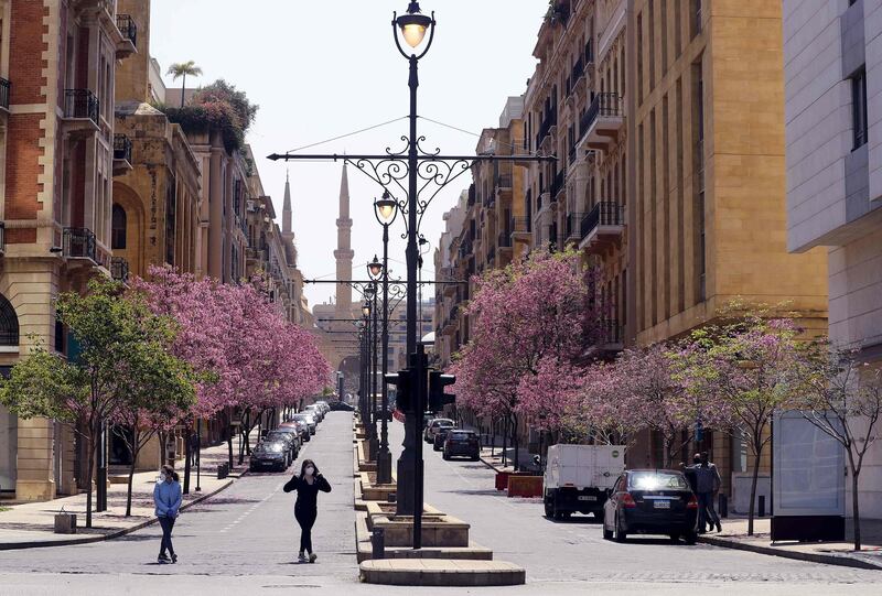 Lebanese women cross an empty street in Beirut's downtown area.  AFP