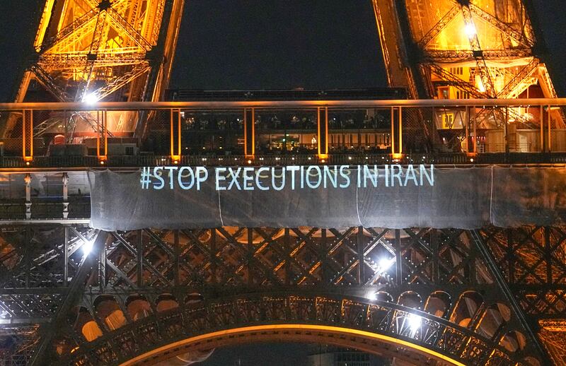 The Eiffel Tower lits the night with the a slogans "Stop Executions in Iran" and "Woman, Life, Freedom" in support for the protests across Iran in Paris, Monday, January 16, 2023. AP