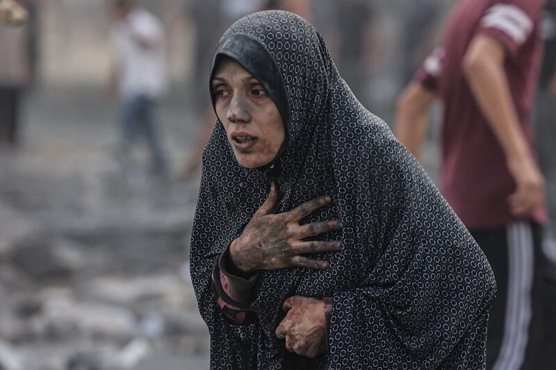A Palestinian woman in shock after air strikes hit buildings near her home in Rafah. AFP