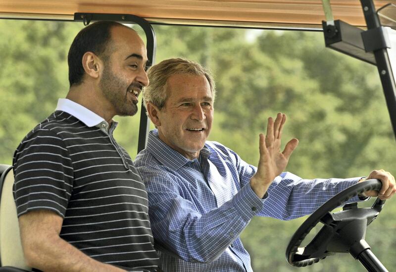 US President George W. Bush (R) waves from a golf cart with Crown Prince of the Emirate of Abu Dhabi Sheikh Mohammad bin Zayed Al Nahyan upon his arrival at Camp David, Maryland, on June 26, 2008.          AFP PHOTO/Jim WATSON (Photo by JIM WATSON / AFP)