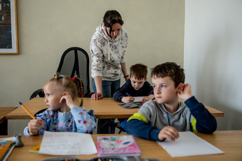 Teacher Katja with Artem, Sofia and Alexander, refugee schoolchildren who are receiving Ukrainian curriculum primary school education in Berlin, Germany. Getty