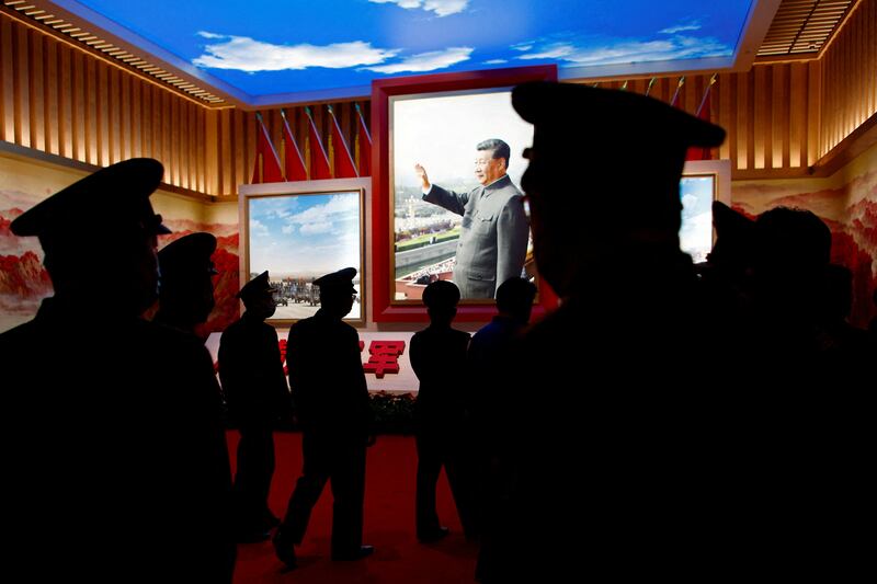 Members of the Chinese People's Liberation Army (PLA) walk past an image of Mr Xi at an exhibition at the Military Museum of the Chinese People's Revolution in Beijing. Reuters