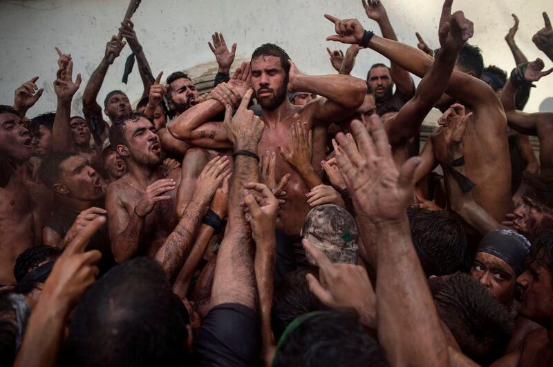 People covered in black grease take part in the festival of the Cascamorras, in Baza, near Granada, Spain. AFP