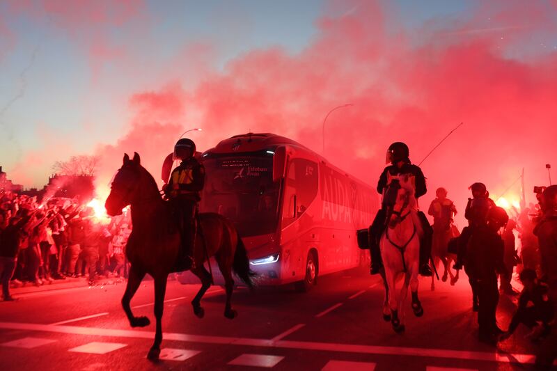 Police escort the Atletico Madrid team coach as fans light flares before the UEFA Champions League last-16 second leg match between Atletico Madrid and Inter at Civitas Metropolitano Stadium in Madrid. Getty Images