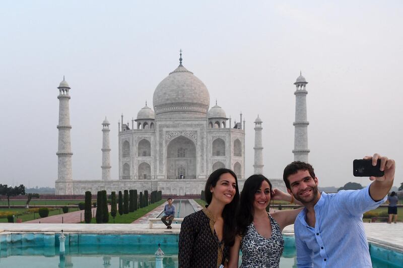 Tourists take pictures as the visit the Taj Mahal in Agra on September 21, 2020. - The Taj Mahal reopened to visitors on September 21 in a symbolic business-as-usual gesture even as India looks set to overtake the US as the global leader in coronavirus infections. (Photo by Sajjad HUSSAIN / AFP)