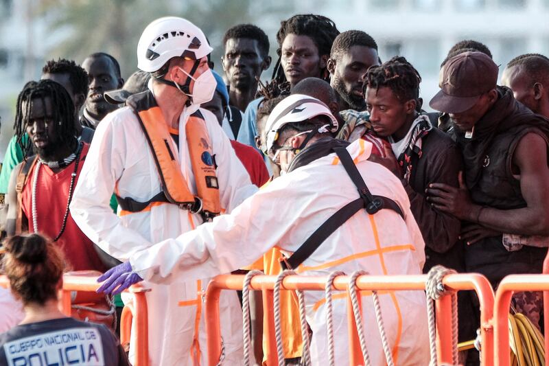 Spanish authorities and maritime safety members assist rescued migrants on their arrival at the port of Arguineguin, the Canary Islands, on July 10. EPA