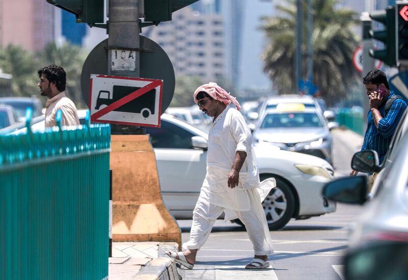 Abu Dhabi, United Arab Emirates, July 15, 2019.  Standalone weather images.  Pedestrians covered with "heat gear" cross the street at downtown Abu Dhabi.
Victor Besa/The National
Section:  NA
Reporter:
