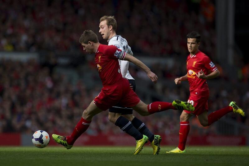 Liverpool FC midfielder Steven Gerrard, left, clears the ball away from Tottenham Hotspur midfielder Christian Eriksen, centre, as Philippe Coutinho looks on during their match at Anfield on Sunday. Jon Super / AP / March 30, 2014