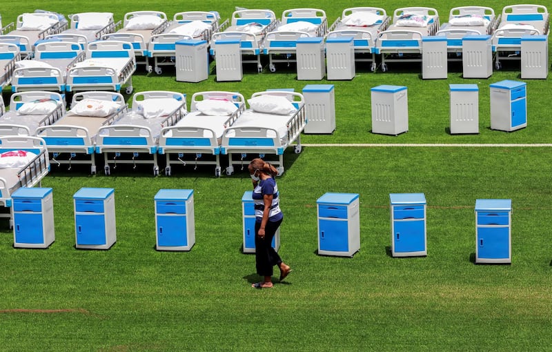 A woman walks past mobile beds arranged outside a new isolation and treatment centre at the Mobolaji Johnson Arena (formerly Onikan Stadium), erected as an additional measure to handle the outbreak of the coronavirus disease (COVID-19), in Lagos, Nigeria. REUTERS