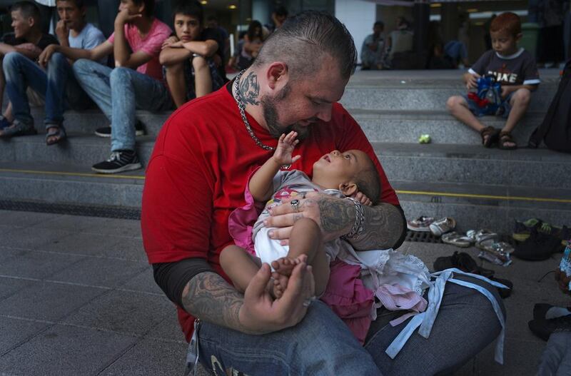 Baba Mujhse holds a newly-arrived migrant baby in front of the Keleti railway station in Budapest, Hungary. Bela Szandelszky/AP Photo