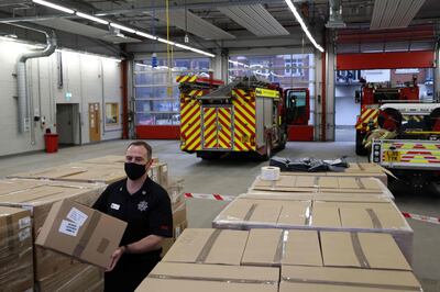 Group commander for West Surrey Fire and Rescue, David Nolan stacks boxes of coronavirus covid-19 testing kits in the Woking fire station in Woking, Surrey, southwest of London, on February 1, 2021. 10,000 kits are being delivered to 5,000 homes in the Goldsworth Park and St Johns areas of Woking as experts seek to urgently test up to 80,000 people in England for Covid-19, after health officials announced on Monday that 11 people had been identified as having contracted the variant that emerged in South Africa. / AFP / Adrian DENNIS
