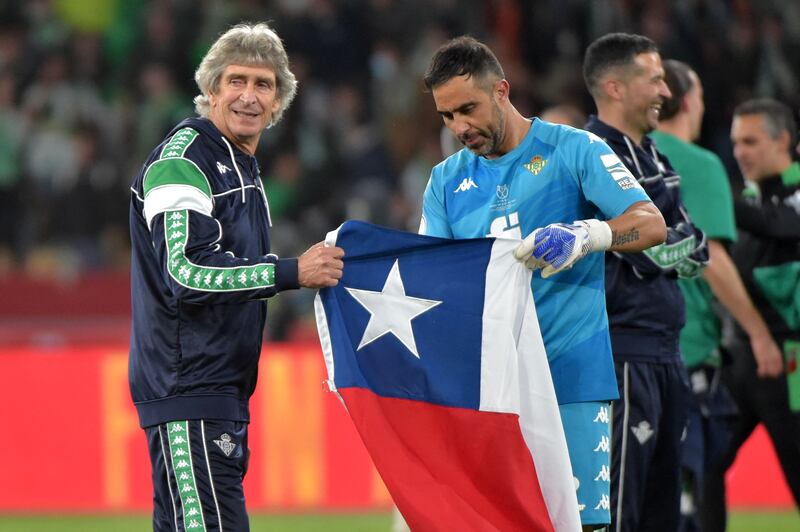 Real Betis coach Manuel Pellegrini and goalkeeper Claudio Bravo hold a Chile flag as they celebrate their Copa del Rey victory. AFP