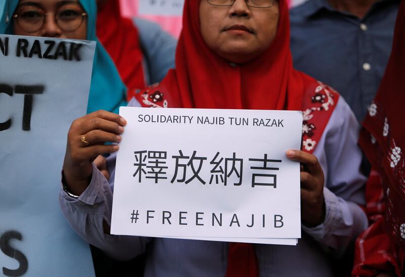 A supporter of former Malaysian prime minister Najib Razak holds up a sign, ahead of his arrival to court in Kuala Lumpur, Malaysia July 4, 2018. REUTERS/Lai Seng Sin
