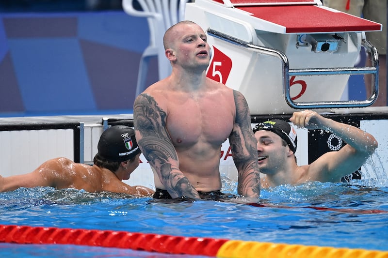 Britain's Adam Peaty , centre, Italy's Nicolo Martinenghi, left, and Netherlands' Arno Kamminga react after the final.