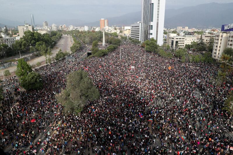 Demonstrators protest against the government in Santiago, Chile, Monday, Nov. 4, 2019. Chile has been facing weeks of unrest, triggered by a relatively minor increase in subway fares. The protests have shaken a nation noted for economic stability over the past decades, which has seen steadily declining poverty despite persistent high rates of inequality. (AP Photo/Esteban Felix)