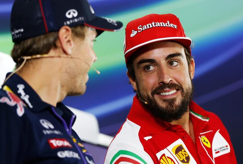 Spanish Formula One driver Fernando Alonso, right, of Ferrari smiles at German Formula One driver Sebastian Vettel of Red Bull Racing during a news conference at Yas Marina Circuit in Abu Dhabi, United Arab Emirates on Thursady. The Abu Dhabi Grand Prix will take place on Sunday.  EPA/VALDRIN XHEMAJ

