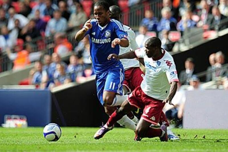 Didier Drogba, left, is fouled by Portsmouth's Aaron Mokoena. The Chelsea striker scored the resulting free-kick to hand the London club a league and FA Cup double.